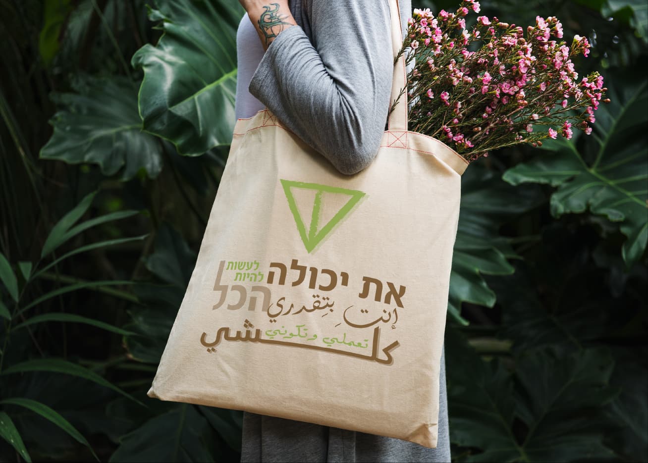 HECA tote bag among greenery and wildflowers